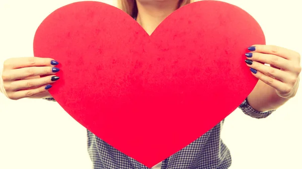 Жінка тримає велике червоне серце, знак любові — стокове фото