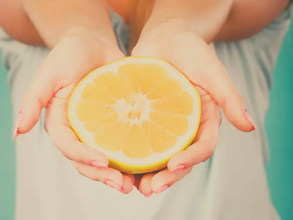 De helft van de gele grapefruit citrusvruchten in menselijke hand — Stockfoto