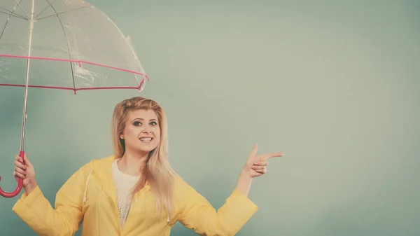 Женщина в плаще, держащая зонтик, указывая — стоковое фото