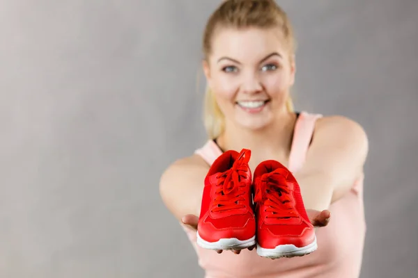 Mujer feliz presentando zapatillas deportivas zapatillas —  Fotos de Stock