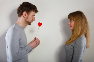 Man giving heart to his girl. clipart
