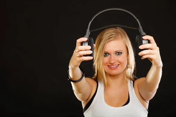 Kobieta blonde holding duże słuchawki w studio — Zdjęcie stockowe
