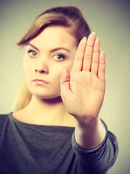 Vrouw toont stopbord door haar hand. — Stockfoto