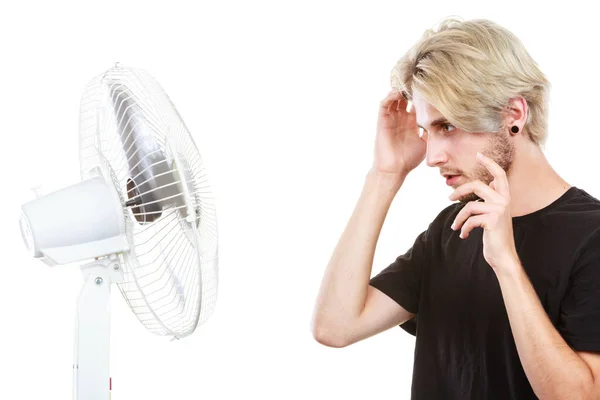 Jovem lutando com o vento do ventilador de refrigeração — Fotografia de Stock