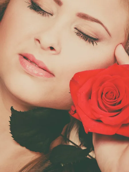 Närbild kvinna med röd ros nära ansikte. — Stockfoto
