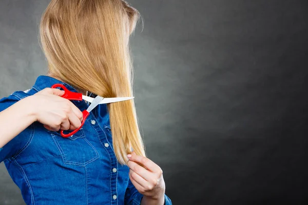 Blondine schneidet sich die Haare. — Stockfoto