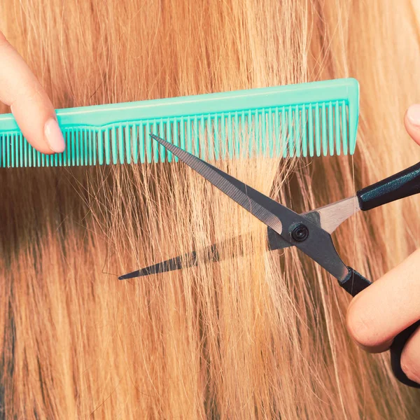 Frau schneidet glatte Haare ab. — Stockfoto