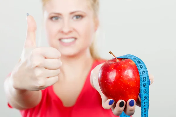 Happy woman holding apple and measuring tape — Stock Photo, Image