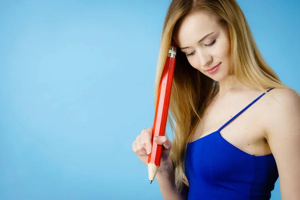 Frau verwirrt, großer Bleistift in der Hand — Stockfoto