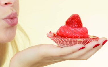 Elinde tatlı çilekli kek tutan bir kadın