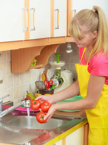 Mujer lavando verduras frescas en la cocina —  Fotos de Stock