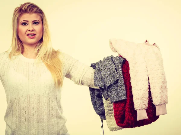 Giyim büyük yığınları tutan kadın