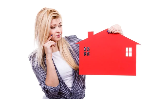 Thinking woman holds red house symbol — Stock Photo, Image