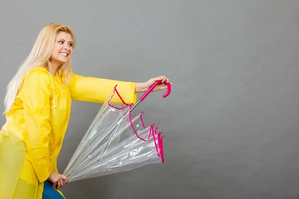 Mulher feliz vestindo capa de chuva segurando guarda-chuva transparente — Fotografia de Stock