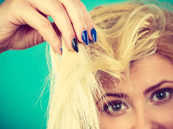 Mulher loira segurando seu cabelo termina — Fotografia de Stock