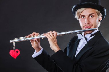 Erkek flütçü flüt ve kalp ile. Melodi seviyorum