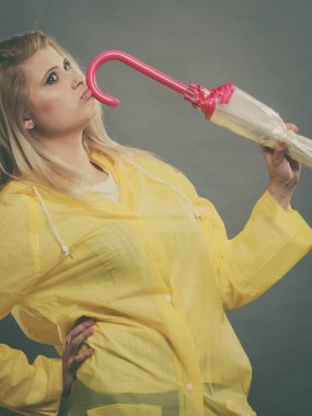 Yağmurluk kapalı tutarak şemsiye giyen düşünme kadın