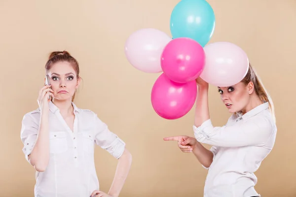 Zwei Mädchen mit Handy und Luftballons — Stockfoto