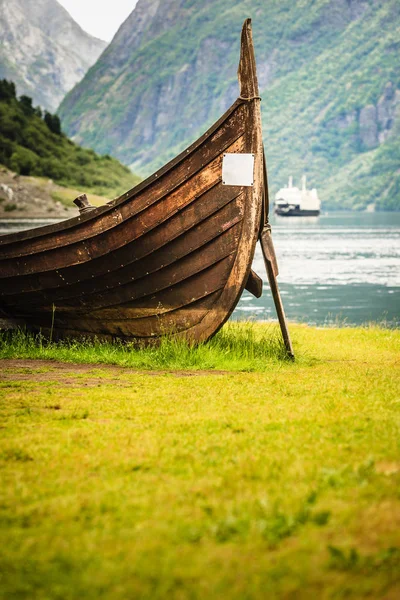 Old viking boat and ferryboat in norwegian fjord