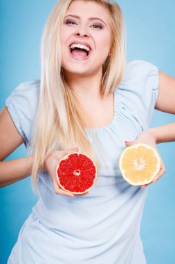 Kırmızı ve yeşil greyfurt tutan kadın