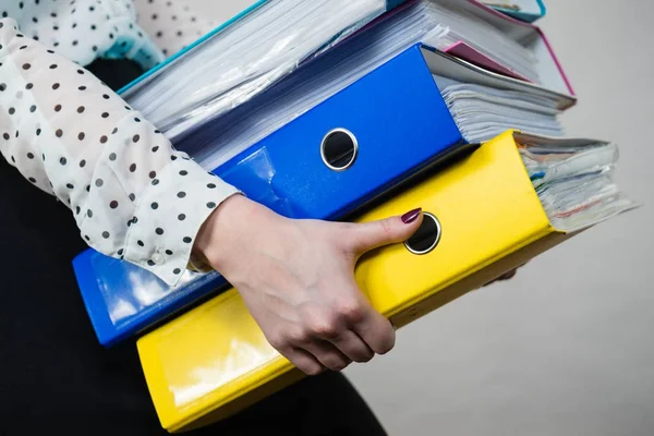 Mulher segurando pesados ligantes coloridos com documentos — Fotografia de Stock