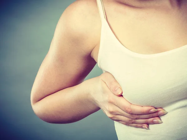 Mujer cogida de la mano sobre su pecho — Foto de Stock