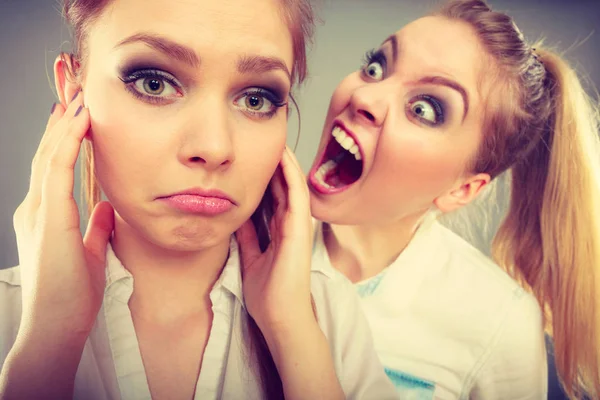 Fury girl screaming at her friend, female closing his ears — Stock Photo, Image