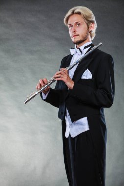 Zarif giyimli müzisyen flüt tutan