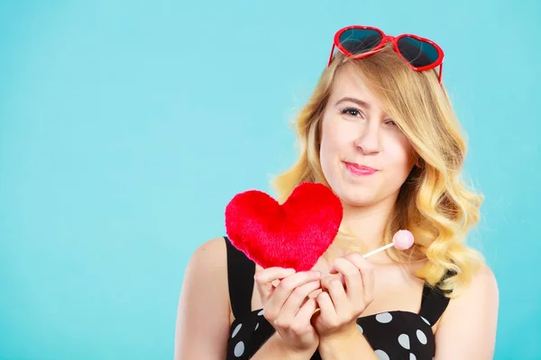 Mujer sostiene corazón rojo símbolo de amor y caramelo piruleta — Foto de Stock