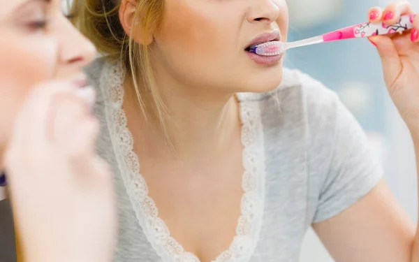 Mujer cepillarse los dientes de limpieza en el baño —  Fotos de Stock