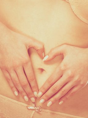 Erkek şekillendirme kalp şekli göbek üzerinde eller.