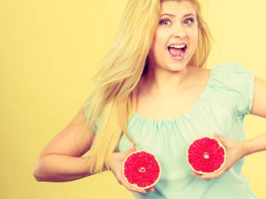 Kırmızı greyfurt meme üzerinde tutan kadın