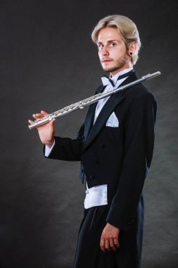 Zarif giyimli müzisyen flüt tutan