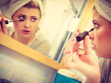 Kadın banyoda maskara kirpik üzerinde uygulama