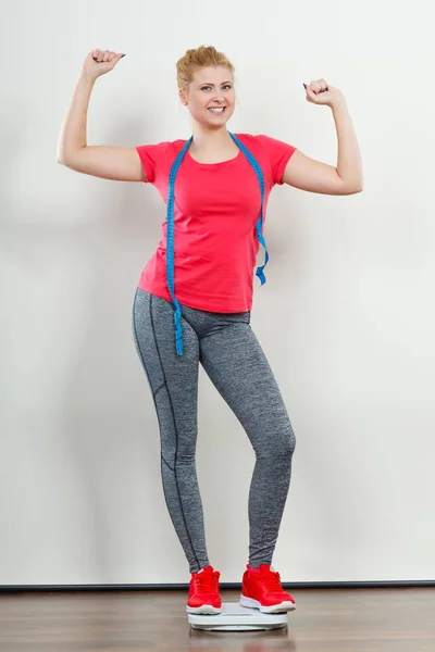 Femme portant des vêtements de sport debout sur la machine de poids — Photo