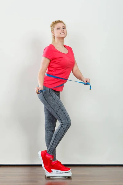 Vrouw het dragen van sportkleding staande op gewicht machine — Stockfoto