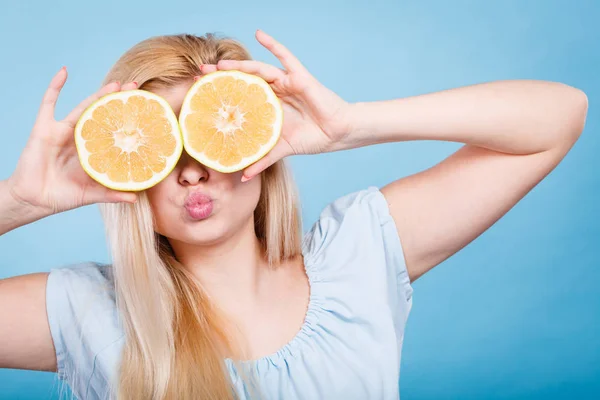 Дівчина прикриває очі грейпфрутами — стокове фото