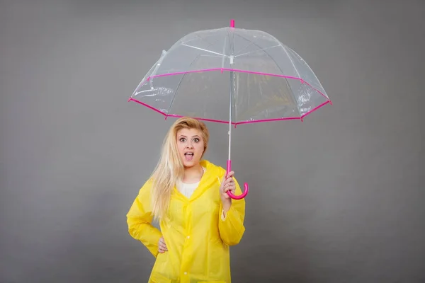 Mujer sosteniendo paraguas transparente mirando sorprendido — Foto de Stock