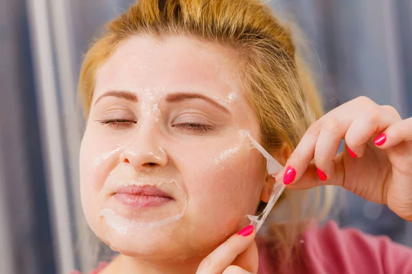 Mujer pelando la máscara de gel de la cara — Foto de Stock