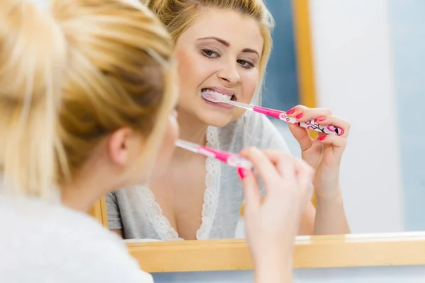 Mujer cepillarse los dientes de limpieza en el baño —  Fotos de Stock