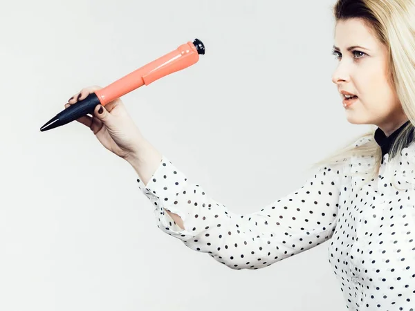 Mulher segurando grande caneta de grandes dimensões — Fotografia de Stock