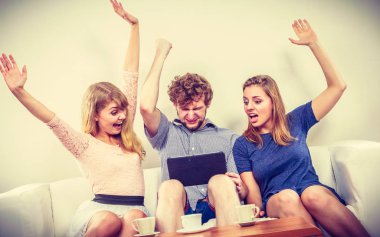 Evde tablet ile başarılı mutlu arkadaşlar.