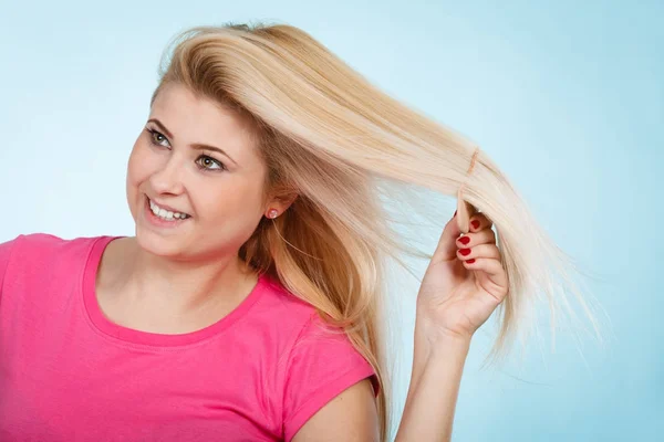 Donna spazzolando i suoi lunghi capelli biondi con pettine — Foto Stock