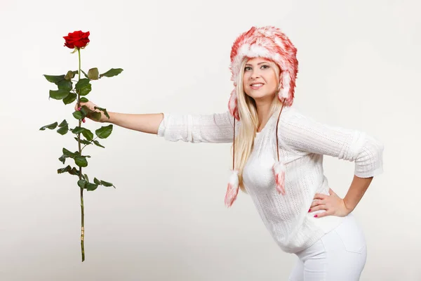 Woman in winter furry hat holding red rose — Stock Photo, Image