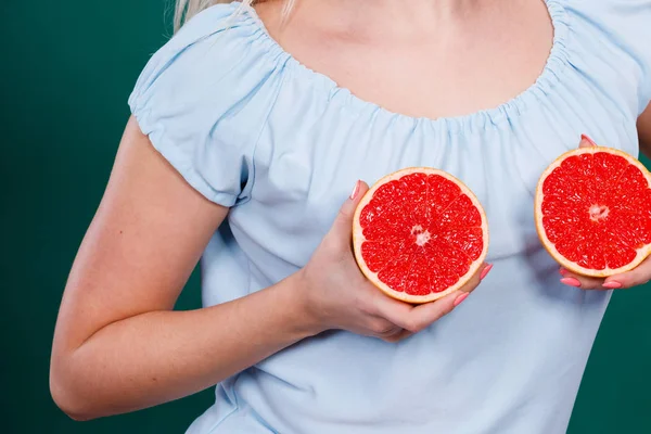 Жінка тримає грейпфрут цитрусові на грудях — стокове фото