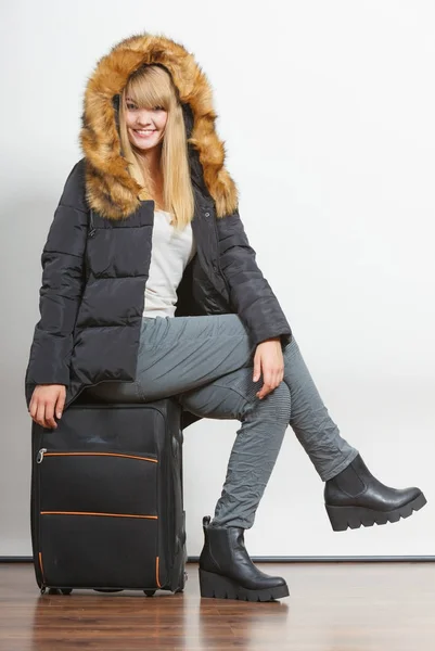 Glückliche junge Frau in warmer Jacke mit Koffer. — Stockfoto