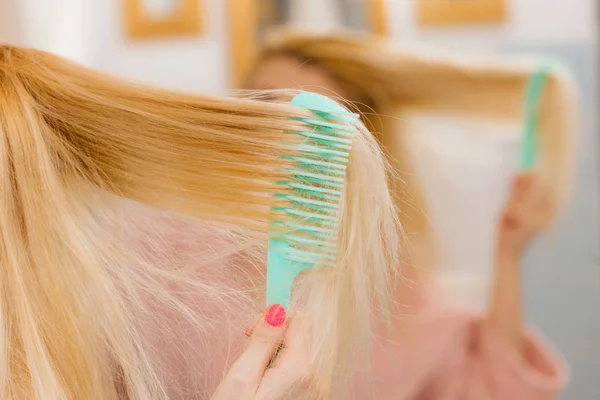 Mujer vestida con bata cepillándose el pelo — Foto de Stock