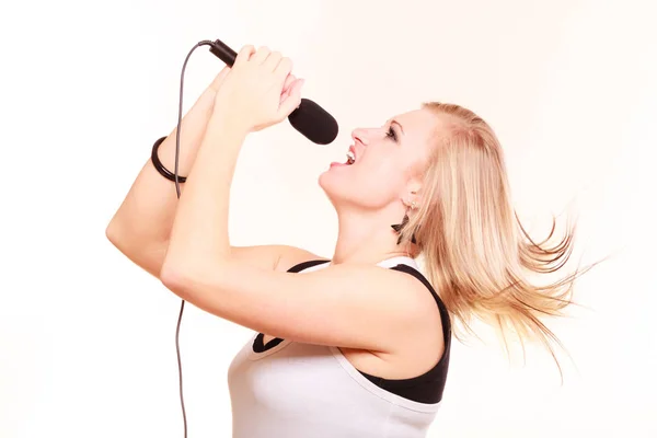 Blond kobieta śpiewa do mikrofonu, widok profilu — Zdjęcie stockowe