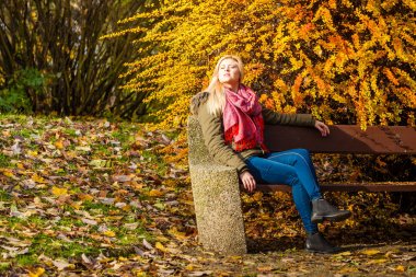 Sonbahar parkta bankta oturmuş rahatlatıcı kadın