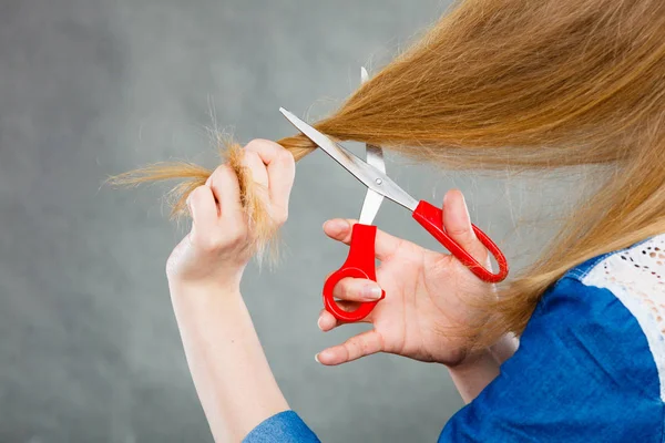 Donna bionda che si taglia i capelli . — Foto Stock
